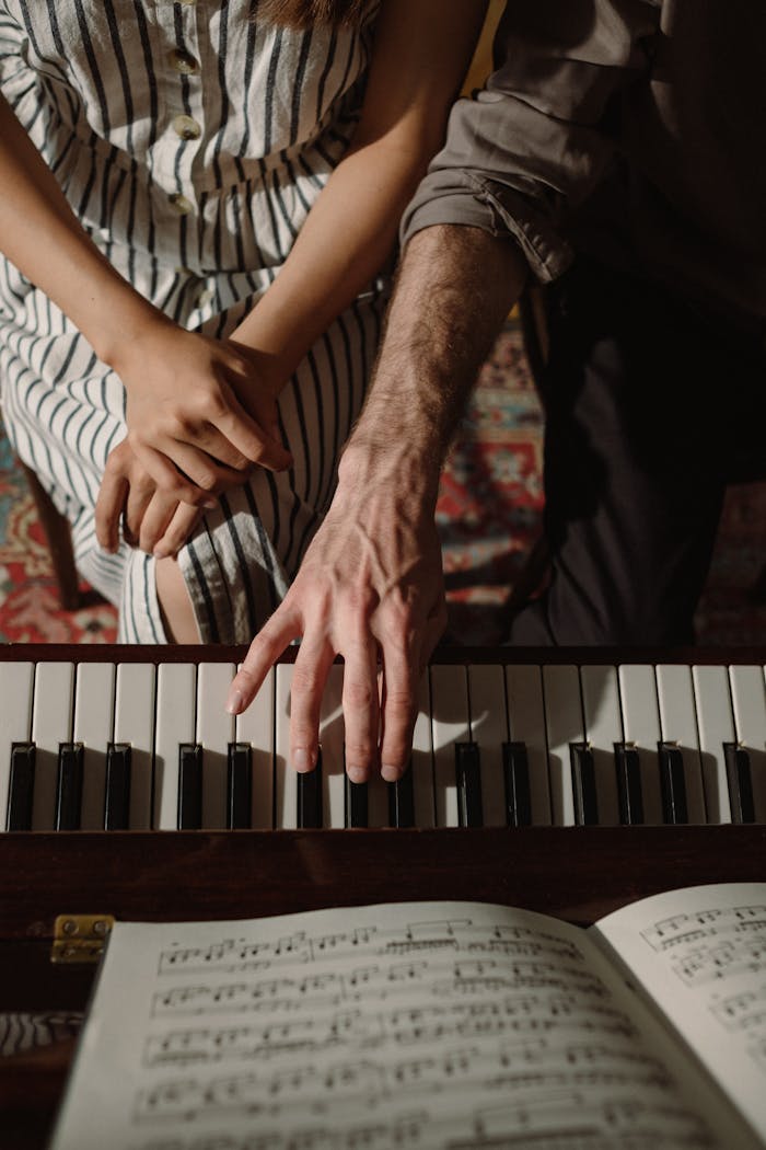 Close-up of a couple's hands playing piano, creating harmonious music together.